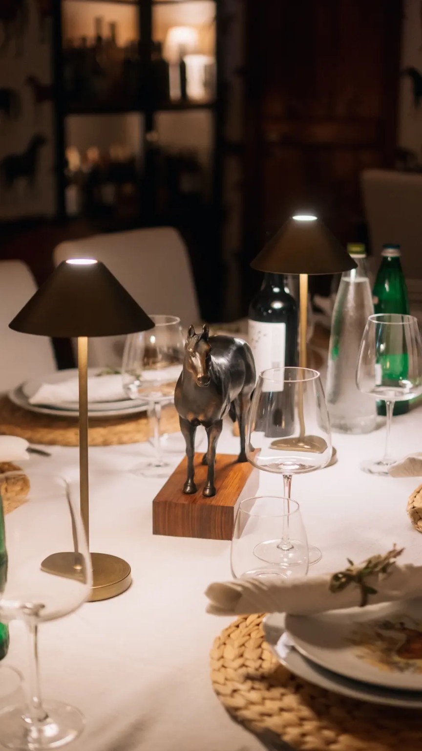 Una tavola di Genuino illuminata dalle lampade per una cena conviviale